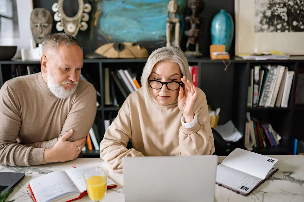 An older couple looking at a laptop
